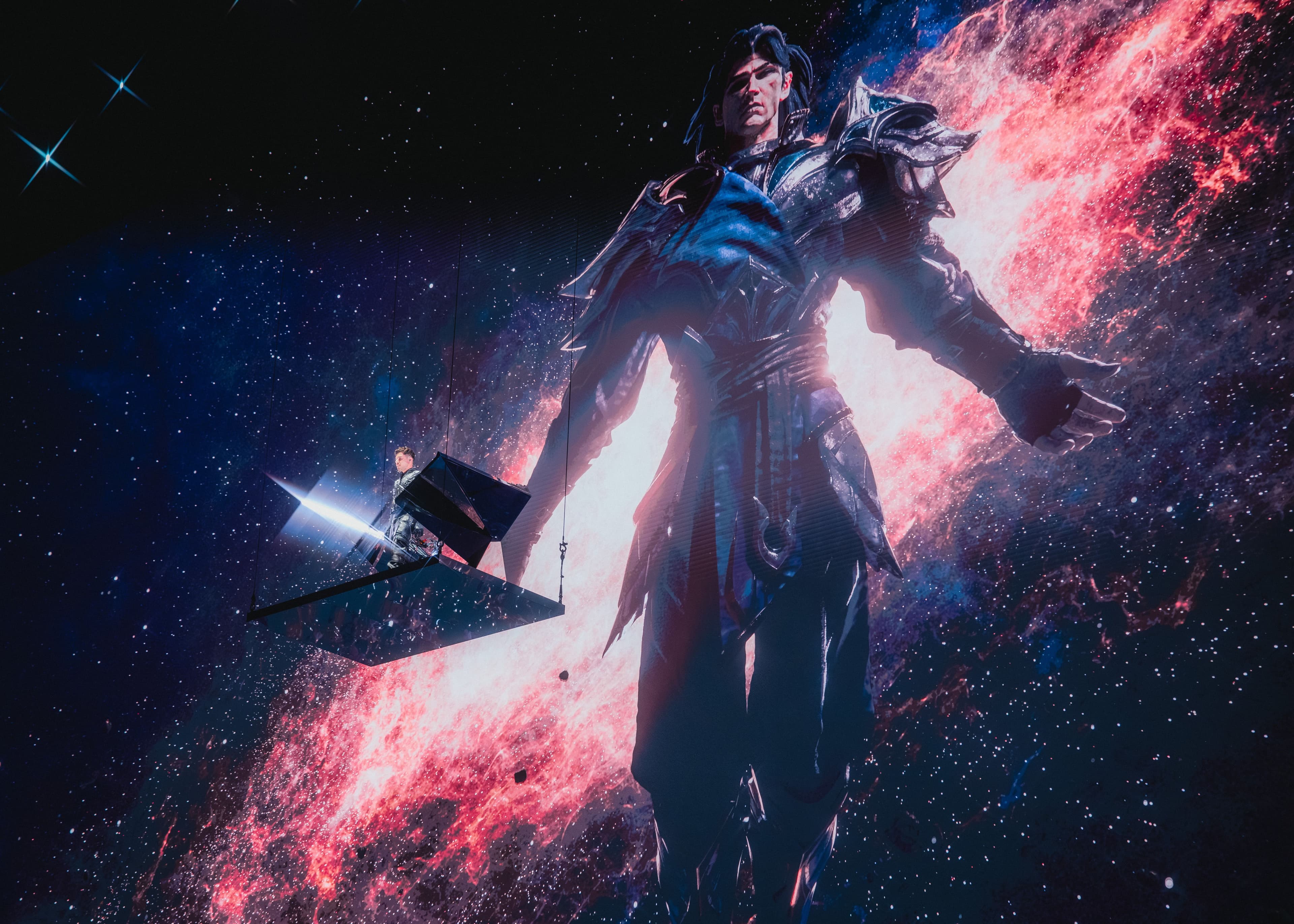 Figure in stylized armor with a glowing cape against a dark, starry backdrop.